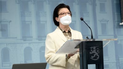 Social- och hälsovårdsministeriets strategichef Liisa-Maria Voipio-Pulkki med vitt munskydd på sig. Hon talar på hälsomyndigheternas presskonferens 3.2.2022.