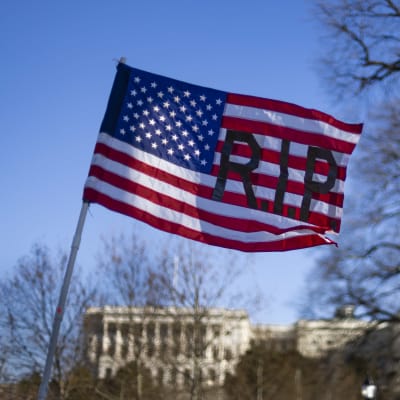 USA:s flagga med texten RIP. I bakgrunden syns Kapitoliums kupol.