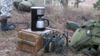 En kaffekokare på en trälåda mitt i naturen/skogen i samband med en manöver, stridsövning i Syndalen