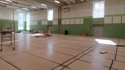 Den blivande gymnastiksalen i det nya skolcentret i Sjundeå. Väggarna går i grönt, halvfärdigt.