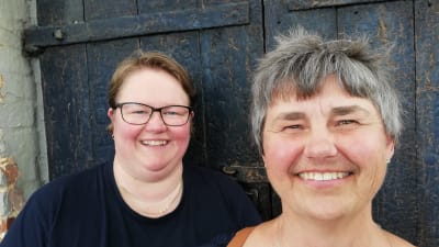 En spelman och en folkdansare vid en svart gammal källardörr.