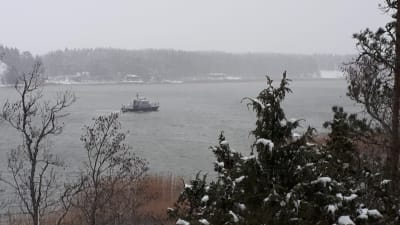 En patrullbåt från Sjöbevakningen kör i ett sund en dimmig vinterdag.
