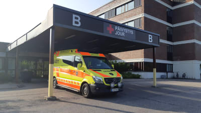 En ambulans är parkerad utanför jouren vid Lojo sjukhus.