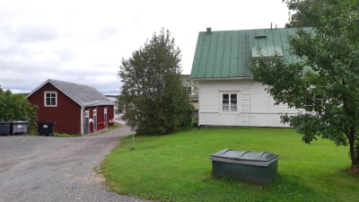 Ett småhus på Åliden i Ingå kyrkby me en röd bod längs ån.