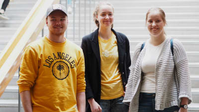 Gymnasieeleverna Eero Tihtonen, Annika Kantokorpi och Carolina Savander står vid trapporna inne i Gymnasiet Lärkan.