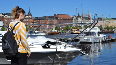 Emmy Nyström står på bryggan vid Skatudden och tittar ner mot vattnet.