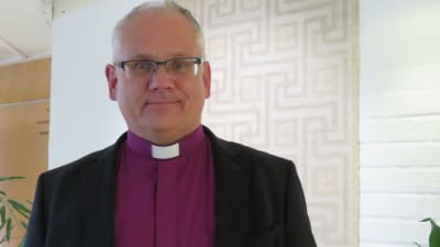 En man i lila skjorta med vit prästkrage och svart jacka. Biskop Bo-Göran Åstrand.