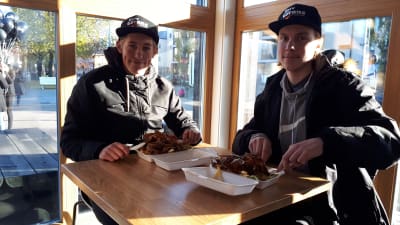 Två ungdomar sitter och äter kebab vid en kebabrestaurang på Brändö i Vasa.
