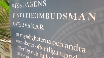 En skylt i riksdagen med texten Riksdagens justitieombudsman övervakar, och exempel på något område 