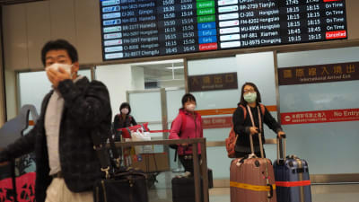 Passagerarna på flygplatsen i Taiwans huvudstad Taipei bar skyddsmasker på söndagen. Samma dag som coronaviruset krävde sitt första dödsoffer i Taiwan, där ett tjugotal människor bekräftats smittade. 