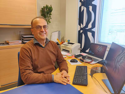 Man sitter vid sitt skrivbord på ett kontor.