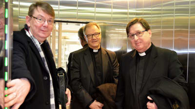 Kyrkoherdarna Stefan Forsén, Roger Rönnberg ochMartin Fagerudd står i en hiss.