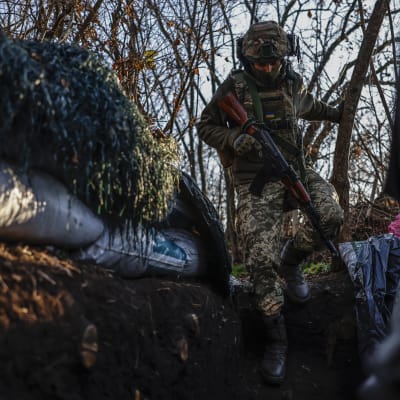 En ukrainsk soldat går ner i en skyttegrav vid fronten i Cherson.