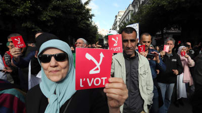 Demonstranter i Algeriet håller upp lappar med texten "nej".