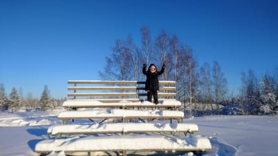 Nainen lumisilla portailla.