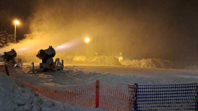Lumikoneet turputtavat lunta iltapimeällä Turun Impivaarassa joulukuussa 2022.