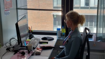 Psykiatrisk sjukskötare Anna Bisi sitter vid sitt skrivbord och tittar ut genom fönstret.