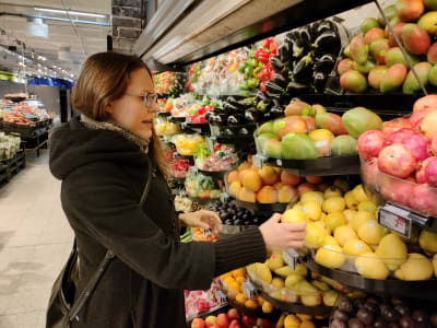 Näringsvetare Charlotta Hyttinen vid frukthyllan i en matbutik.