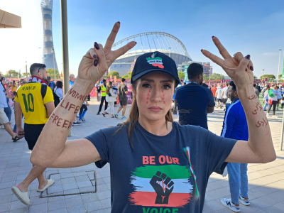 En iransk kvinna som protesterar mot regimen, iklädd skärmmössa och t-skjorta med slagorden Be Our Voice.
