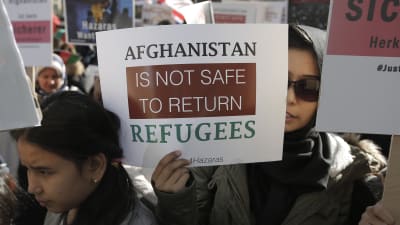 Demonstranter i Bryssel när EU ordnar konferens om läget i Afghanistan. På skylten som en kvinna håller står det: Det är inte säkert att återbörda flyktingar till Afghanistan.