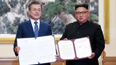 Moon Jae-in och Kim Jong-un visar upp undertecknade avtal.
