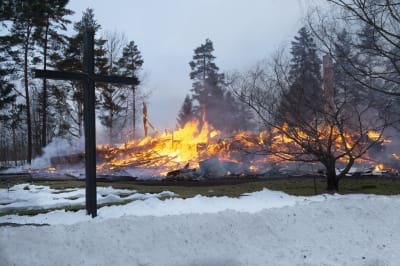 Rautjärven kirkon rauniot tulessa.
