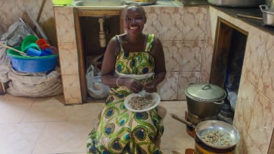 Gladys Ayakaka lagar mat på en energieffektiv spis i Uganda.