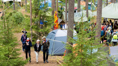 Tält och ungdomar i skogen.
