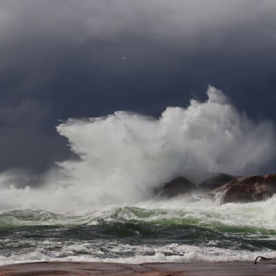 Stormvågor, vinden piskar upp vatten i luften. 