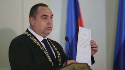 Ukrainska separatiskledaren Igor Plotnitskij svär en ed år 2014.