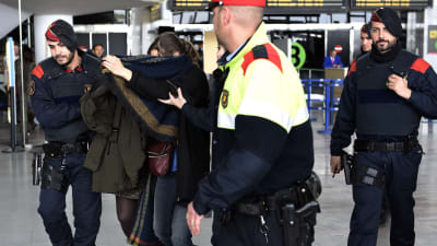 Anhöriga till ett offer av flygraschen i Frankrike eskorteras av polisen på Barcelonas flygplats El Prat
