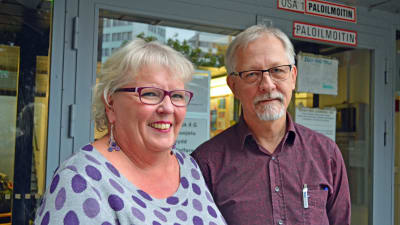Auli Lindroos och Martti Marila poserar framför en dörr till socialverket i Helsingfors.