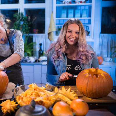 två kvinnor skär i pumpor