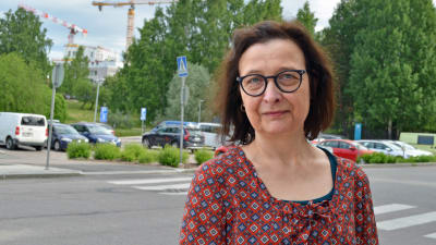 Barbara Bergbom poserar, i bakgrunden parkerade bilar.