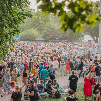Publik på festivalen Kesärauha i Åbo. Det är soligt och grönt.