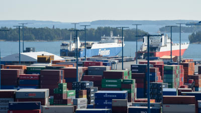 Vy över Nordsjö hamn med containrar i förgrunden och skärgård och fraktfartyg i bakgrunden.