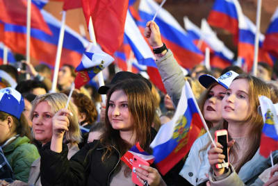 Venäläiset kokoontuvat juhlimaan seremonian jälkeen, jossa allekirjoitettiin sopimuksia uusien alueiden liittämisestä Venäjään Punaiselle torille Moskovassa 30.9.2022.