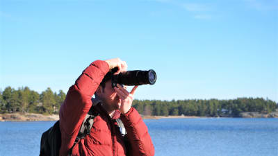 Naturfotograf Christian Alfthan med sin kamera på Högholmens naturstig i Hangö. 