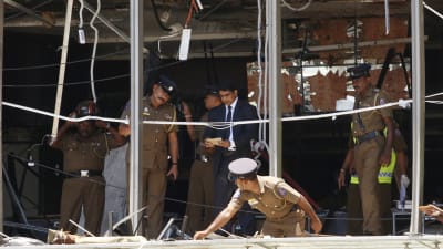 Myndigheter granskar en söndersprängd lokal i hotellet Shangri La i Sri Lanka.