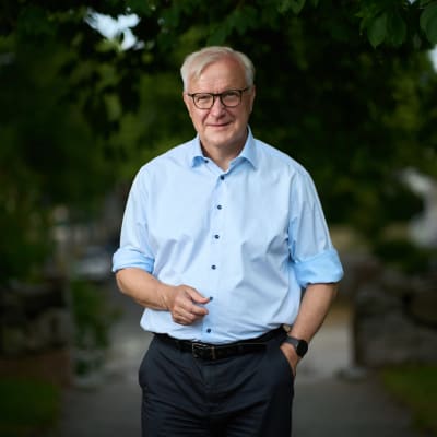 Mies seisoo kävelykadun keskellä vehreässä ympäristössä.