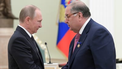 Vladimir Putin och  Alisher Usmanov skakar hand.