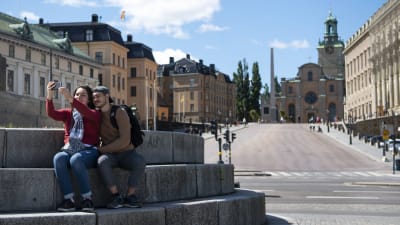 Turister i Stockholm utanför kungliga slottet.