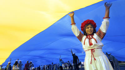 Ukrainsk flicka i folkdräkt håller fupp landets flagga under självständighetsdagen 24.8.2012