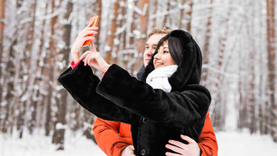 Ett par tar en selfie i en snöig omgivning.