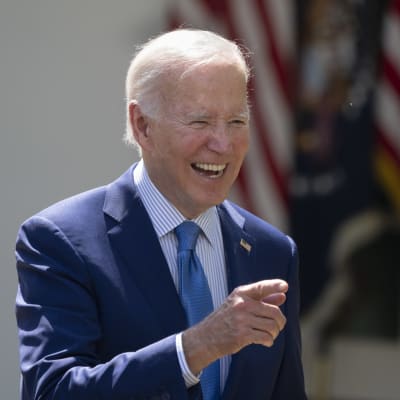 Joe Biden nauraa ja osoitta sormellaan.