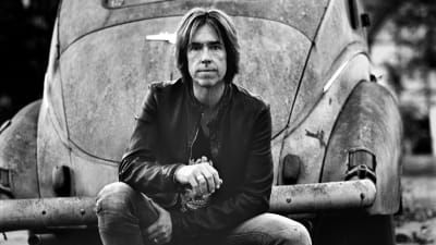 Per Gessle fotograferad framför gammal amerikansk bil.