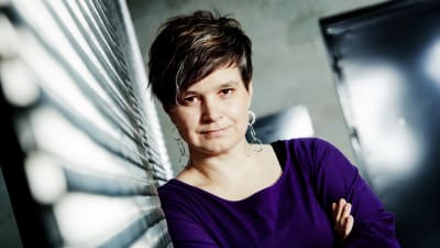 Mia Franck nojaa kädet puuskassa seinään ja katsoo intensiivisesti kameraan.