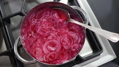 Picklad rödlök i en kastrull.