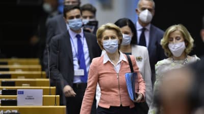Ursula von der Leyen i grupp där alla bär munskydd, på väg in i mötessal