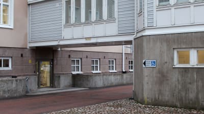 En skylt pekar mot en dörr som passar dem som är rullstolsburna